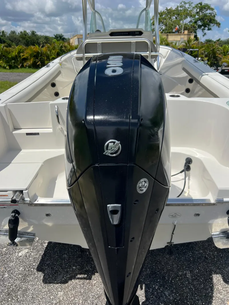 Slide: The Image of 2021 Sailfish 242 CC boat with powerful outboard motor, parked outdoors. - 33