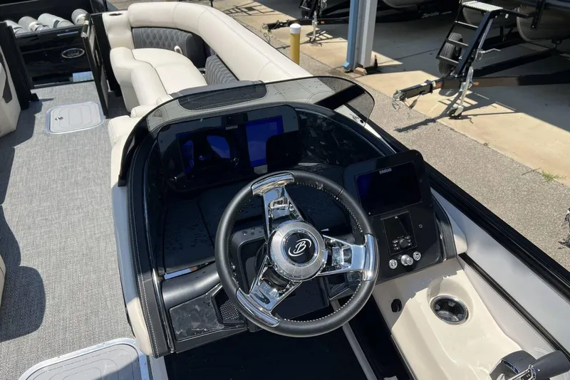 Slide: The Image of 2026 Barletta L25UCA boat interior with steering wheel and seating area. - 11