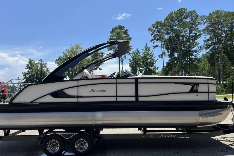 Slide: The Image of 2026 Barletta L25UCA pontoon boat on trailer, parked outdoors under clear sky. - 21