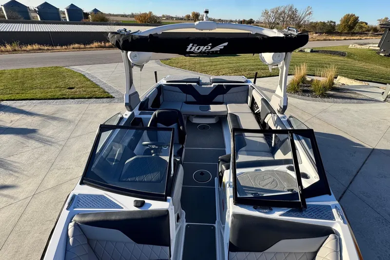 Slide: The Image of 2021 Tigé Z3 boat with open seating, parked on concrete near grass and silos. - 23