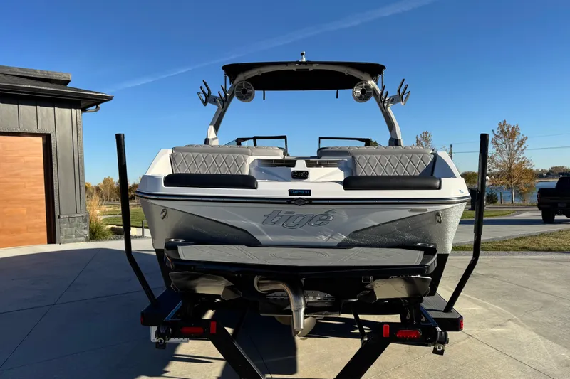 Slide: The Image of 2021 Tigé Z3 boat on trailer, parked outdoors under clear blue sky. - 8