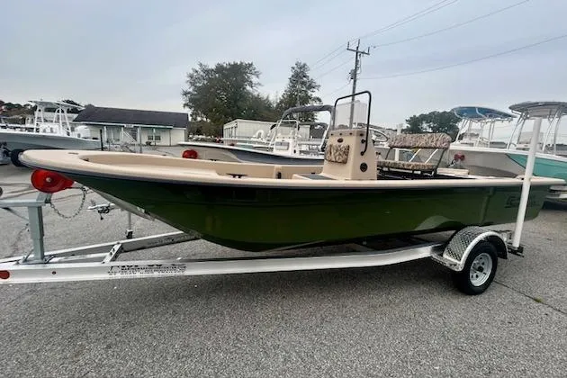 The Image of 2026 Carolina Skiff E20 JVX CC boat on trailer, green hull, parked outdoors. - 0