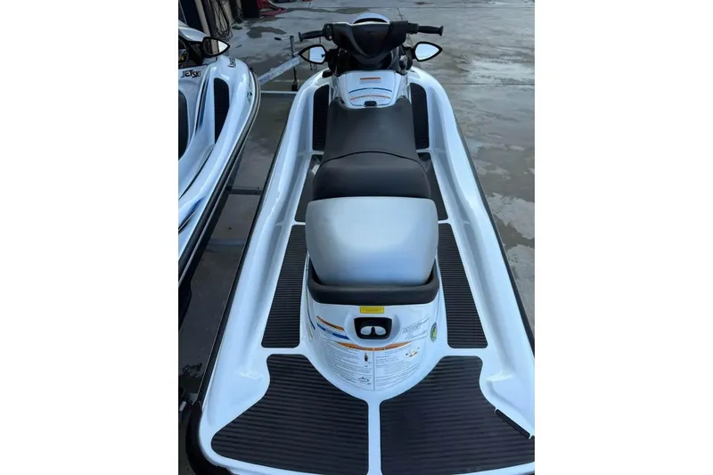 Slide: The Image of 2013 Kawasaki STX15F jet ski, white and black, parked on wet pavement. - 10
