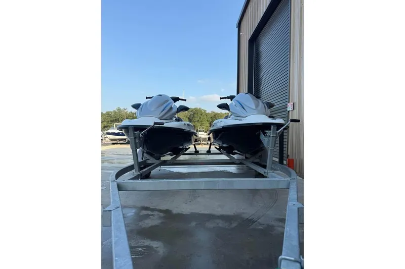 Slide: The Image of 2013 Kawasaki STX15F jet skis on trailer near storage facility. - 8