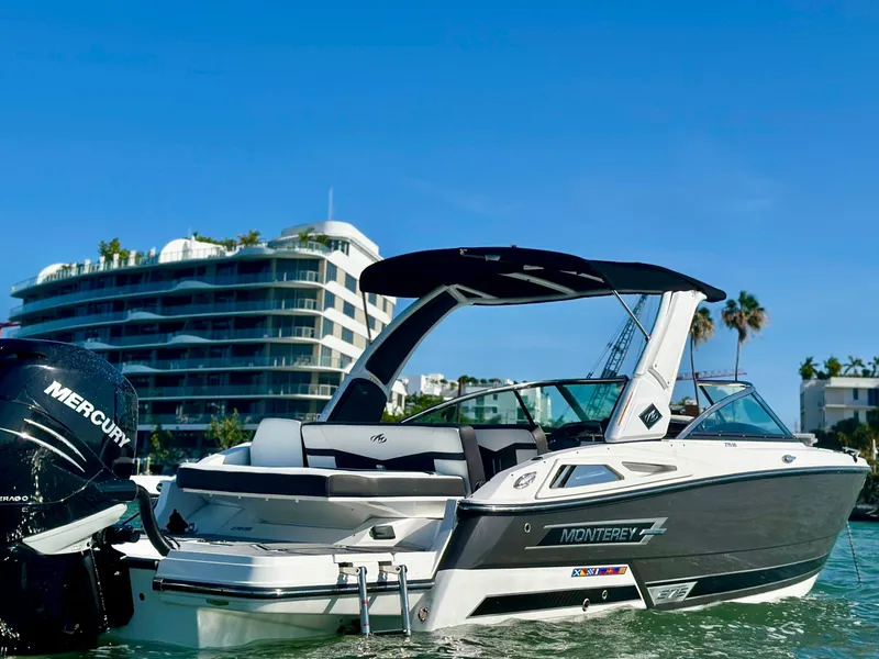 The Image of 2022 Monterey 275 Super Sport boat on water, modern building in background. - 0