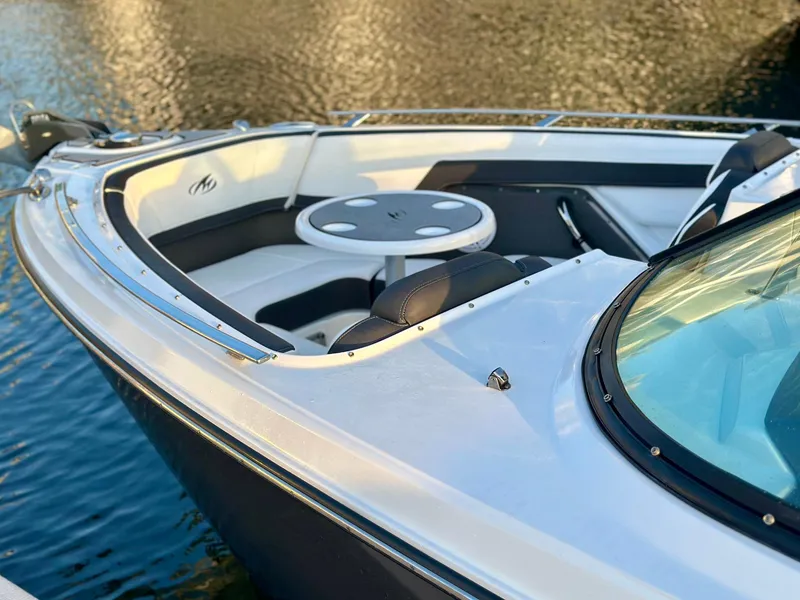 Slide: The Image of 2022 Monterey 275 Super Sport boat, sleek design, white and black interior, on calm water. - 11