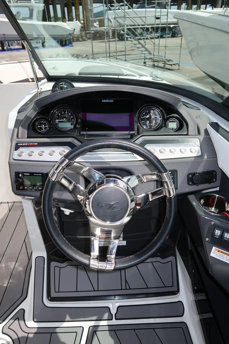 Slide: The Image of 2022 Monterey 275 Super Sport boat dashboard with modern steering wheel and controls. - 13