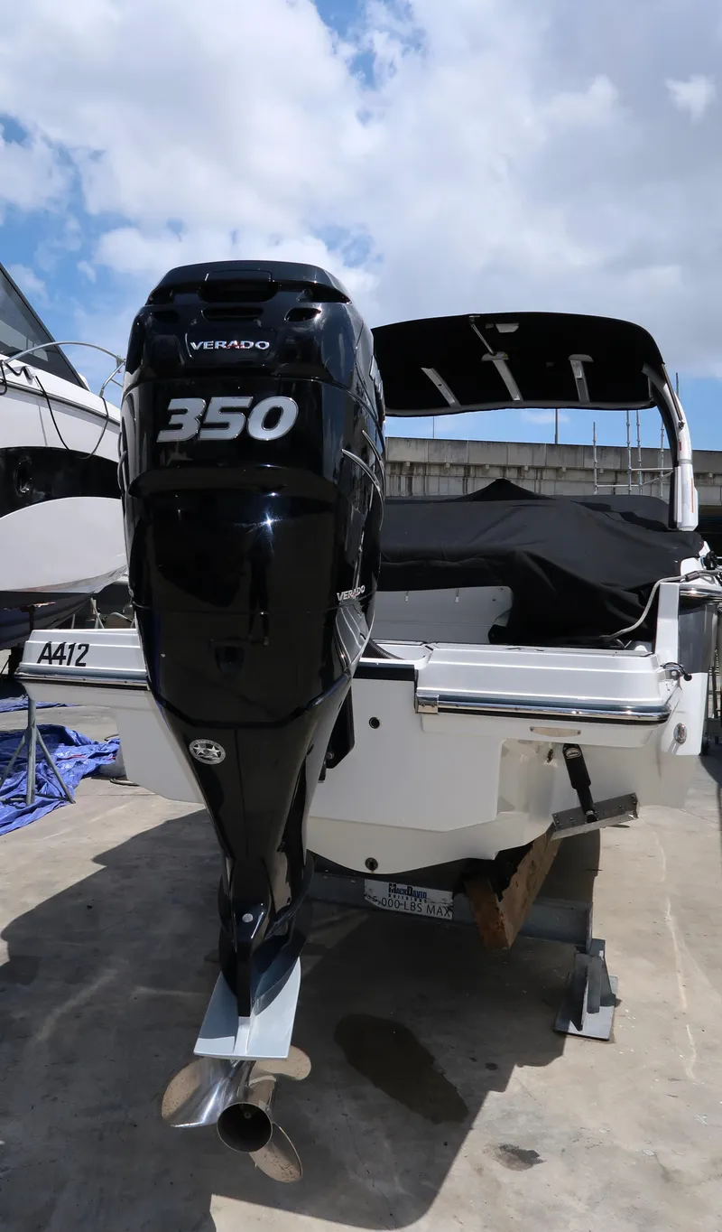 Slide: The Image of 2022 Monterey 275 Super Sport boat with powerful 350 engine, docked under a cloudy sky. - 23