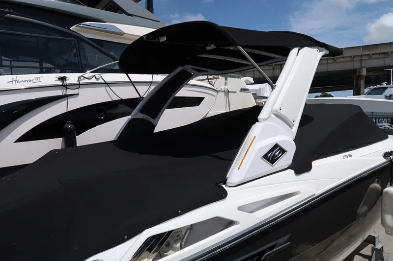 Slide: The Image of 2022 Monterey 275 Super Sport boat with black cover and sleek design. - 9
