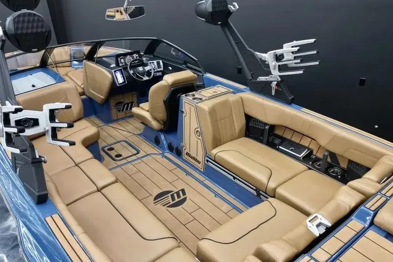 Slide: The Image of 2024 Malibu Wakesetter 24 MXZ interior with tan seating and modern dashboard. - 10