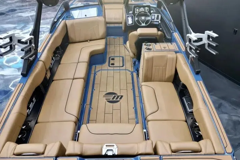Slide: The Image of 2024 Malibu Wakesetter 24 MXZ interior with tan seating and modern dashboard. - 11
