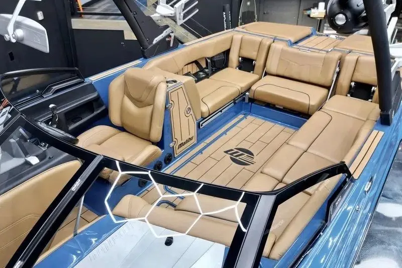 Slide: The Image of 2024 Malibu Wakesetter 24 MXZ interior with luxurious tan seating and sleek blue accents. - 8