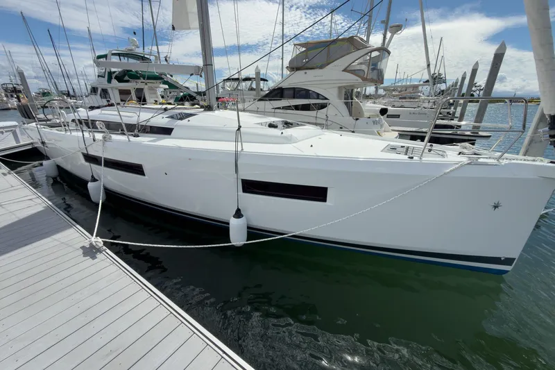 Slide: The Image of 2025 Jeanneau Sun Odyssey 440 sailboat docked at marina under clear sky. - 24