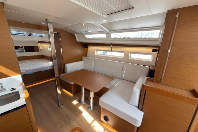 Slide: The Image of Interior of 2025 Jeanneau Sun Odyssey 440 yacht, featuring modern seating and dining area. - 27