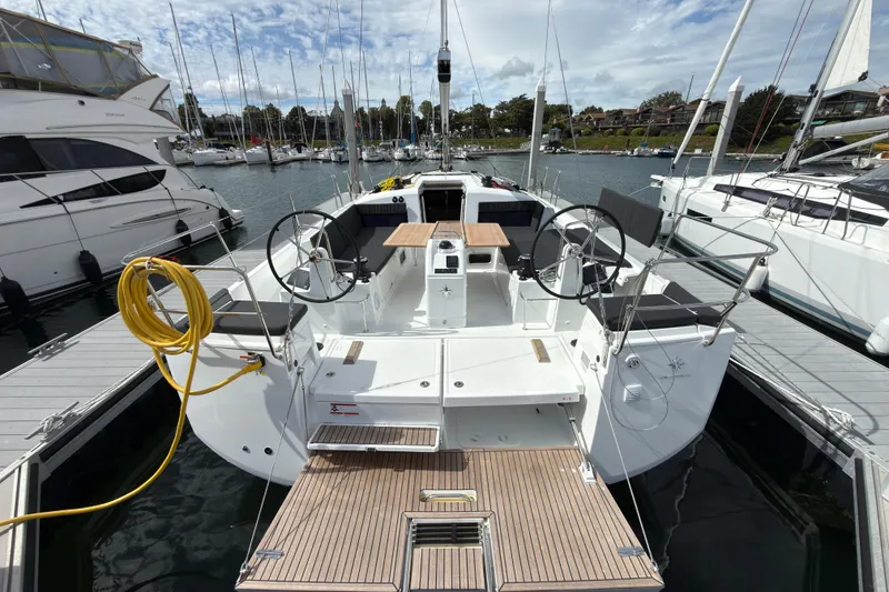Slide: The Image of 2025 Jeanneau Sun Odyssey 440 sailboat docked at marina, featuring dual steering wheels. - 36