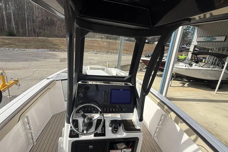 Slide: The Image of 2024 Yamaha Boats 255 FSH Sport E dashboard with steering wheel and navigation display. - 11