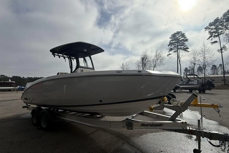 Slide: The Image of 2024 Yamaha Boats 255 FSH Sport E on trailer, parked outdoors under cloudy sky. - 13