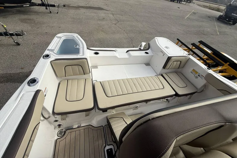 Slide: The Image of 2024 Yamaha Boats 255 FSH Sport E interior with beige seating and storage compartments. - 17