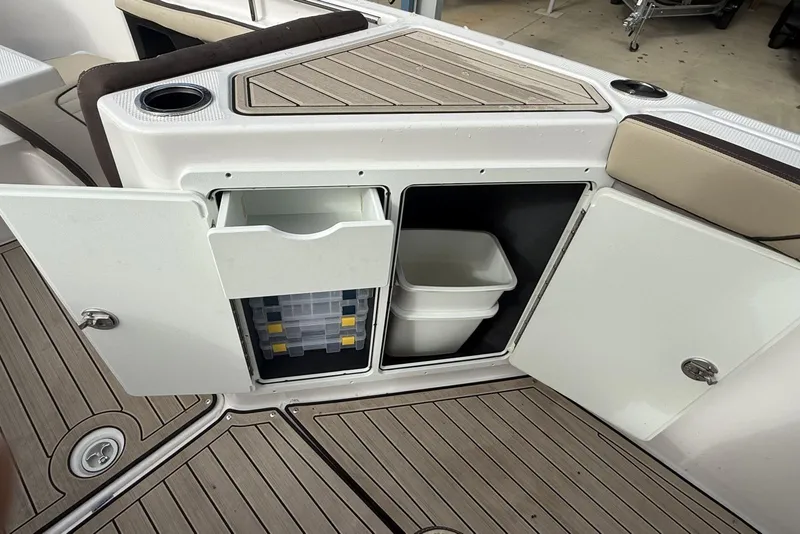 Slide: The Image of 2024 Yamaha Boats 255 FSH Sport E storage compartments with tackle box and bin. - 20