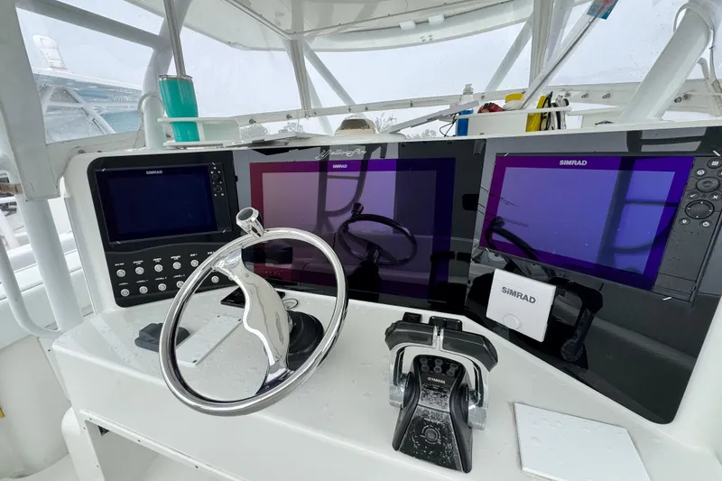 Slide: The Image of 2011 Yellowfin 42 Offshore helm with Simrad displays and modern steering wheel. - 10
