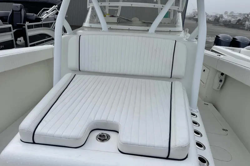 Slide: The Image of 2011 Yellowfin 42 Offshore boat with white cushioned seating and rod holders. - 17