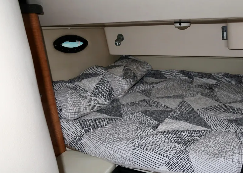 Slide: The Image of 2004 Regal 2665 Commodore cabin with geometric-patterned bedding. - 13