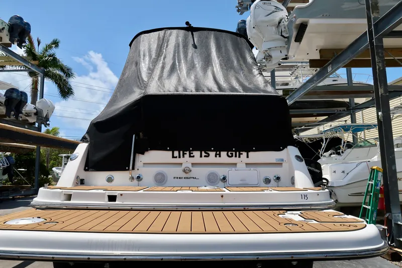 Slide: The Image of 2004 Regal 2665 Commodore boat with covered deck, docked in marina. - 2
