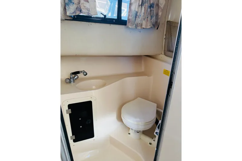 Slide: The Image of 2001 Grady-White Sailfish 282 boat bathroom with toilet, sink, and window. - 5