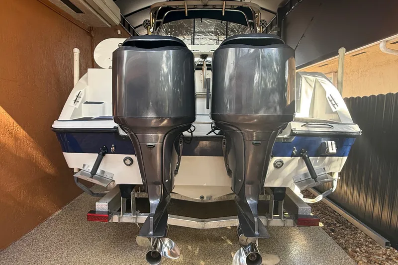 Slide: The Image of 2005 Seaswirl Striper 290 boat with dual outboard motors in a garage. - 10
