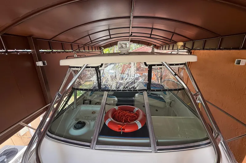 Slide: The Image of 2005 Seaswirl Striper 290 boat under shelter, featuring a life preserver on deck. - 15