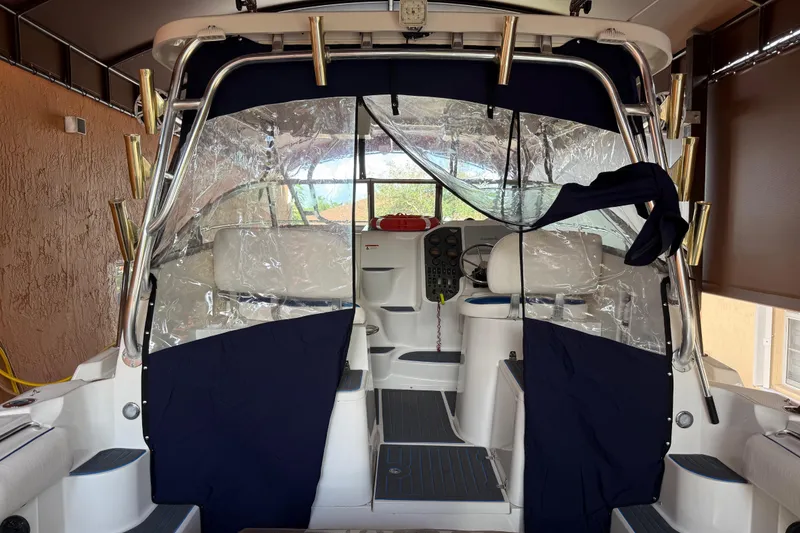 Slide: The Image of 2005 Seaswirl Striper 290 boat interior with clear protective covers and fishing rod holders. - 18