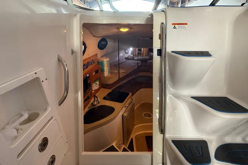 Slide: The Image of Interior view of 2005 Seaswirl Striper 290 boat cabin with kitchenette and seating area. - 24