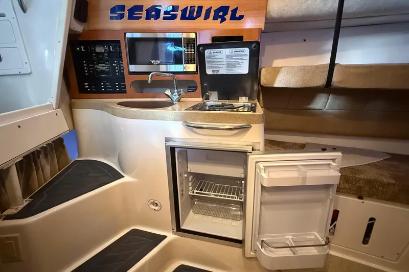Slide: The Image of 2005 Seaswirl Striper 290 boat interior with kitchenette, sink, and open fridge. - 34