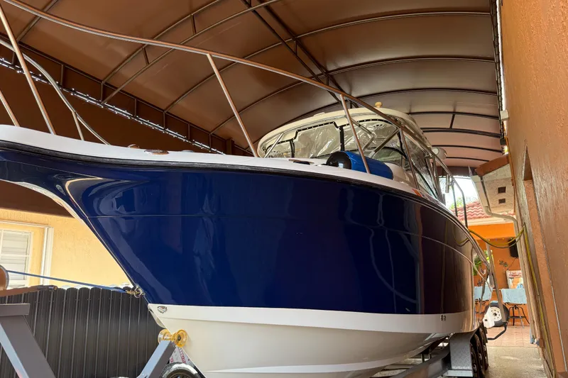 Slide: The Image of 2005 Seaswirl Striper 290 boat in covered storage, showcasing sleek blue hull design. - 4