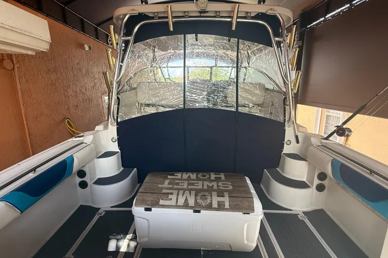 Slide: The Image of 2005 Seaswirl Striper 290 boat interior with seating and cooler, docked in a covered area. - 16