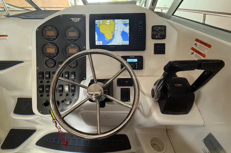 Slide: The Image of 2005 Seaswirl Striper 290 helm with steering wheel, gauges, and navigation system. - 20