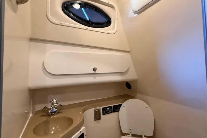 Slide: The Image of 2005 Seaswirl Striper 290 boat bathroom with sink, toilet, and porthole window. - 27