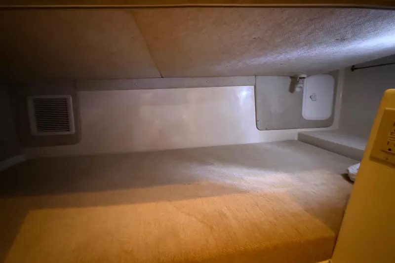 Slide: The Image of 2005 Seaswirl Striper 290 cabin interior with carpeted flooring and storage compartments. - 32