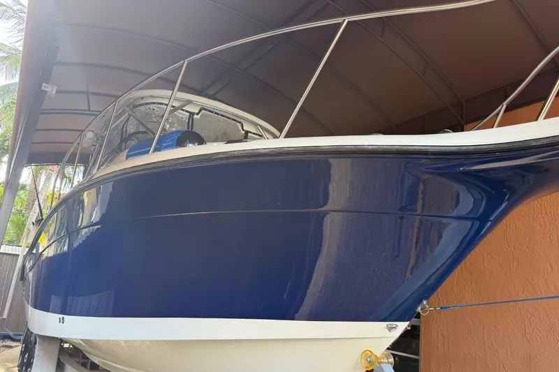 Slide: The Image of 2005 Seaswirl Striper 290 boat with blue hull under a canopy. - 5