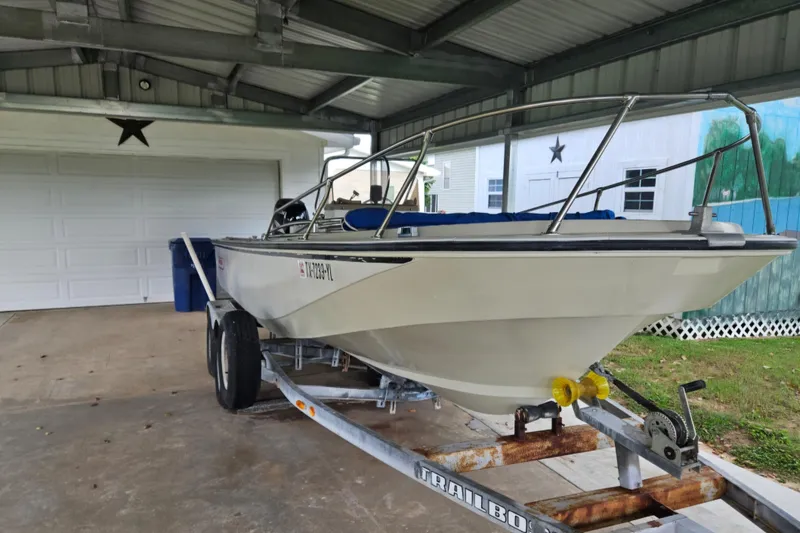 Slide: The Image of 1980 Boston Whaler Outrage 20 boat on trailer under metal carport. - 1