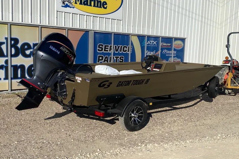 Slide: The Image of 2026 G3 Gator Tough 18 CC boat with Yamaha engine, parked outside marine service center. - 5