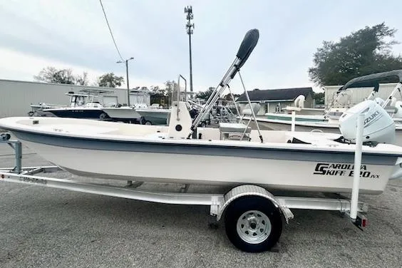 The Image of 2026 Carolina Skiff E20 JVX CC boat on trailer, parked outdoors. - 1