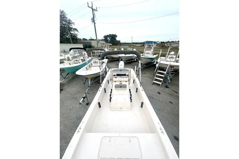 Slide: The Image of 2026 Carolina Skiff E20 JVX CC boat in a marina, surrounded by other boats. - 8