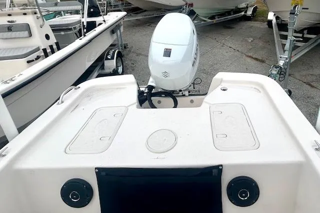 Slide: The Image of 2026 Carolina Skiff E20 JVX CC boat with outboard motor, docked in a marina. - 9