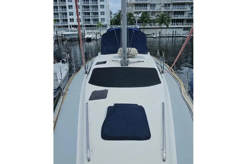Slide: The Image of 1997 Hunter Passage 42 sailboat docked at marina with modern buildings in background. - 20