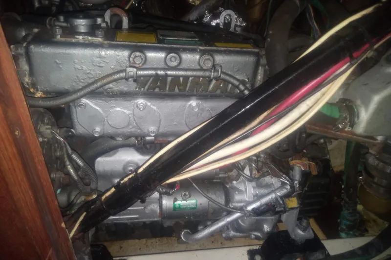 Slide: The Image of Engine compartment of a 1997 Hunter Passage 42 sailboat, featuring mechanical components and wiring. - 24