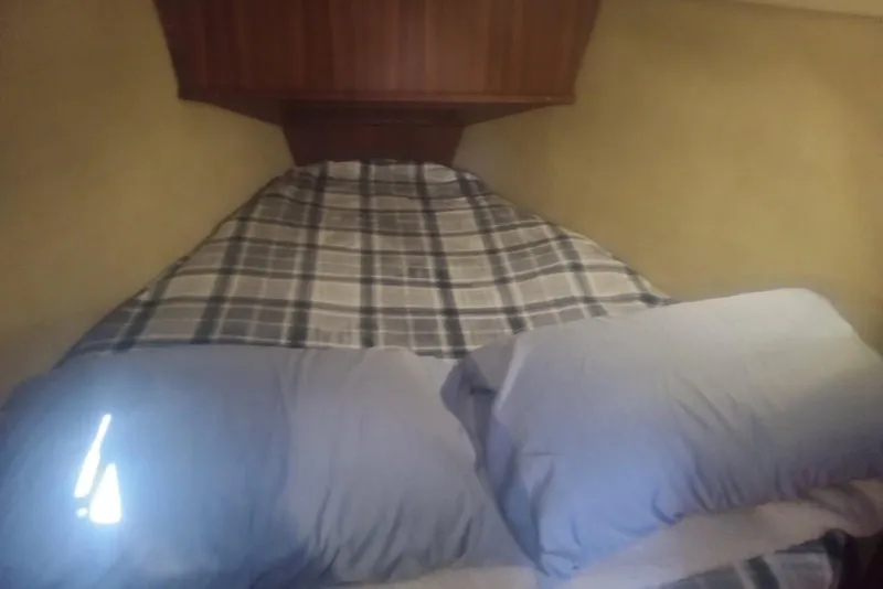 Slide: The Image of Cozy cabin bed in 1997 Hunter Passage 42 sailboat with plaid bedding and pillows. - 5