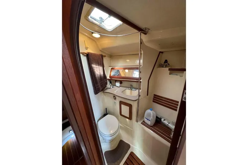 Slide: The Image of 1997 Hunter Passage 42 yacht bathroom with sink, toilet, and wooden accents. - 9