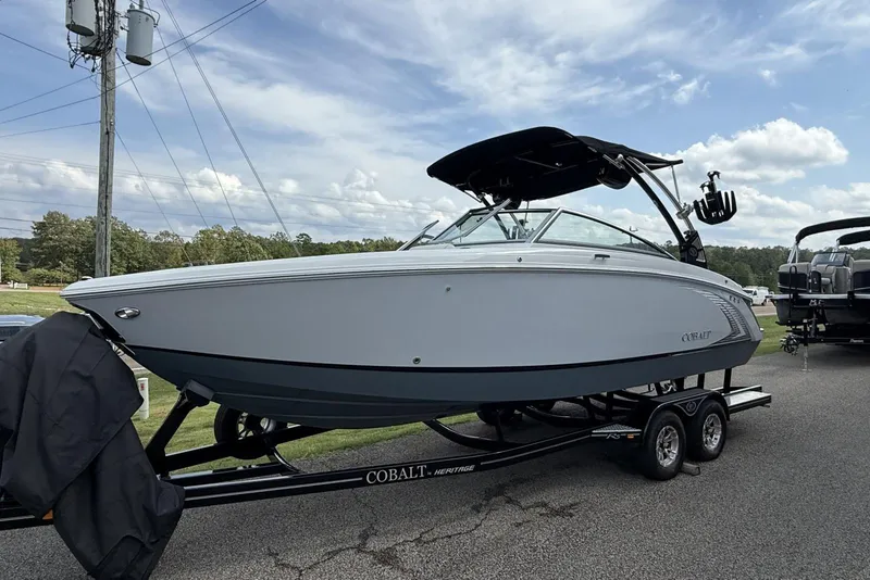 The Image of 2020 Cobalt R5 Surf boat on trailer, parked outdoors under a partly cloudy sky. - 6