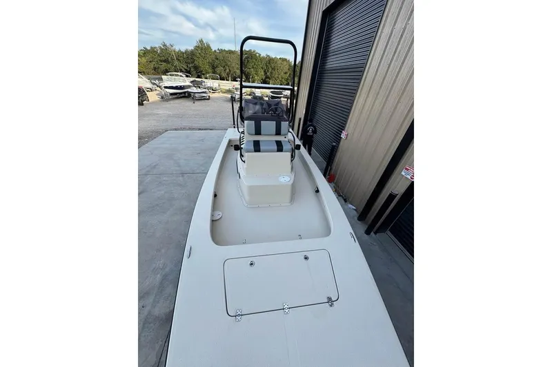 Slide: The Image of 2013 Majek 226 Illusion boat docked near a warehouse, showcasing its deck and console. - 9